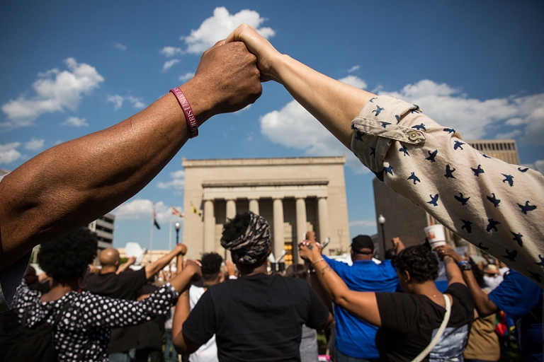 People_hold_hands_during_a_rally_lead_by_faith_leaders_in_front_of_Baltimore_City_Hall_on_May_3_2015_in_Baltimore_Maryland_Credit_Andrew_Burton_Getty_Images_CNA.jpg
